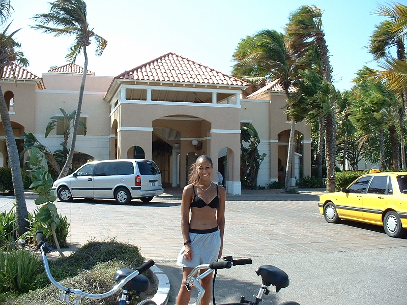 Aruba_002.JPG - Kim posing in front of the resort.  Neat open-concept foyer and reservation desk...only in the tropics!