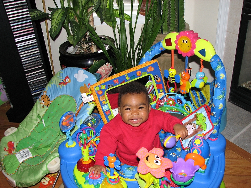 Halloween_Swim_084.JPG - She has soo much fun in the exersaucer...she's holding her new rattle...it apparently makes a great hammer too!  *sigh*